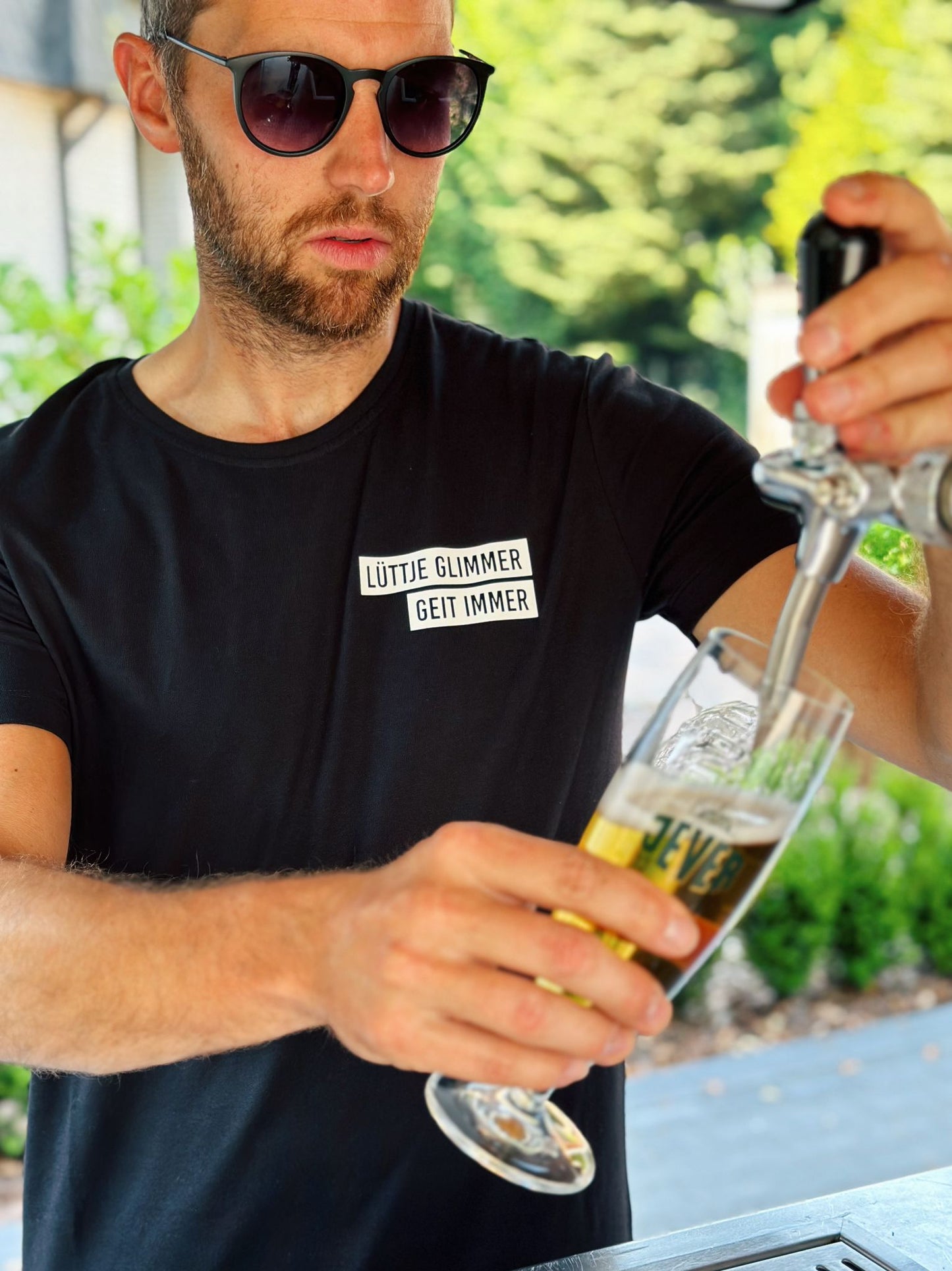 Schwarzes Herren T-Shirt mit "Lüttje Glimmer geit immer" Logo