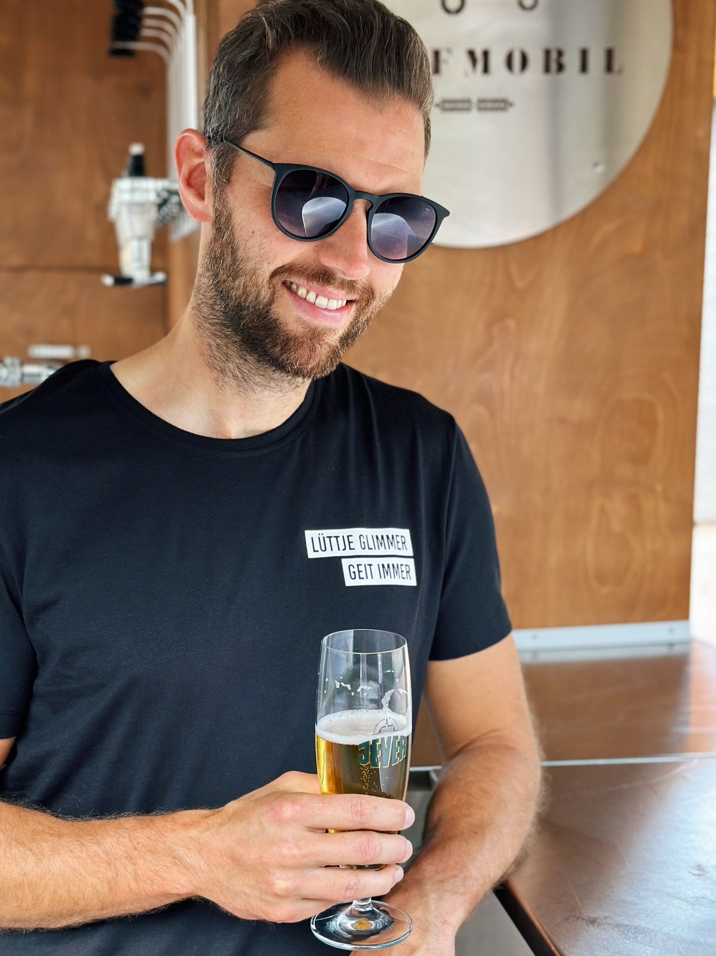 Schwarzes Herren T-Shirt mit "Lüttje Glimmer geit immer" Logo