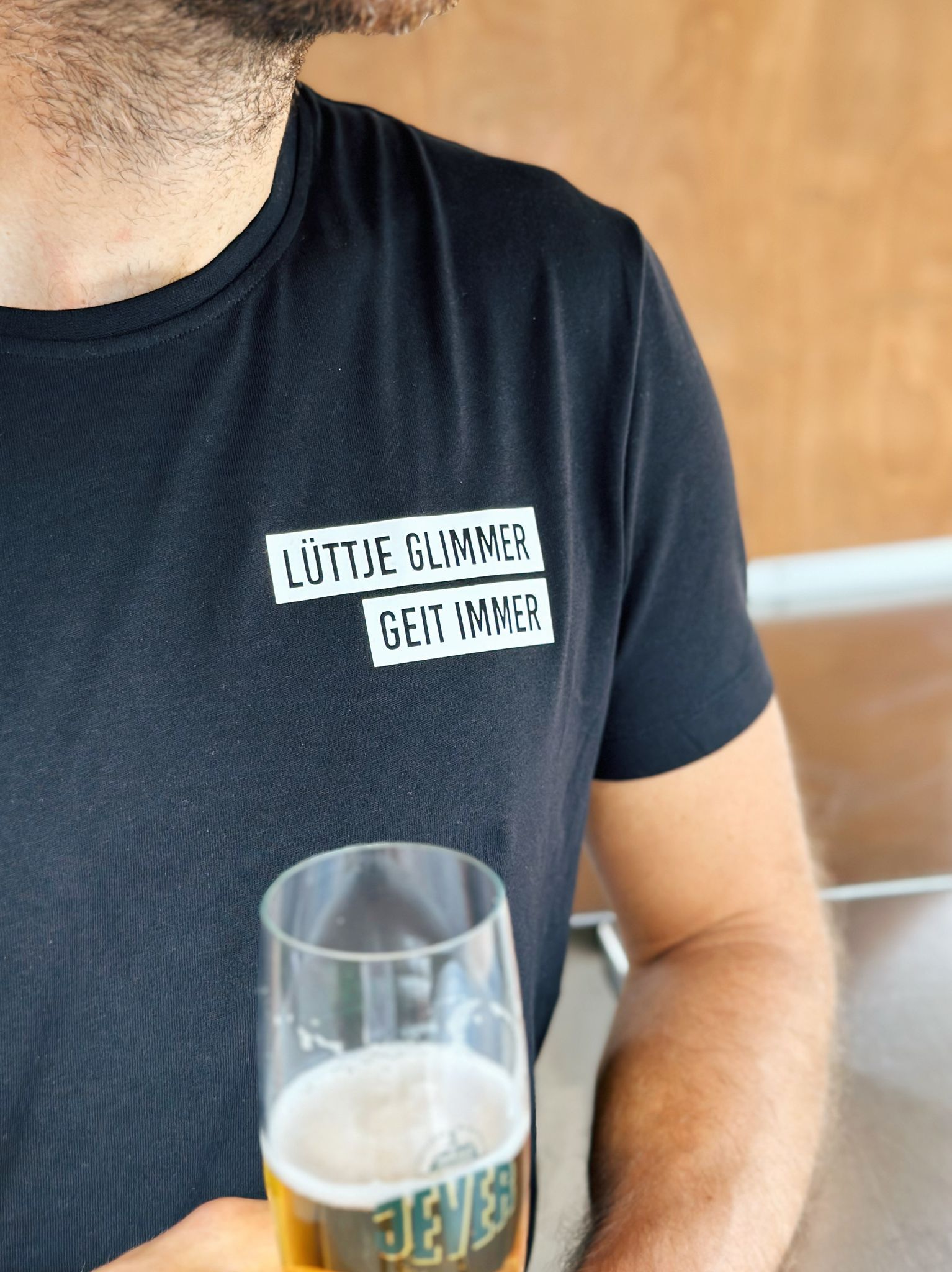 Schwarzes Herren T-Shirt mit "Lüttje Glimmer geit immer" Logo