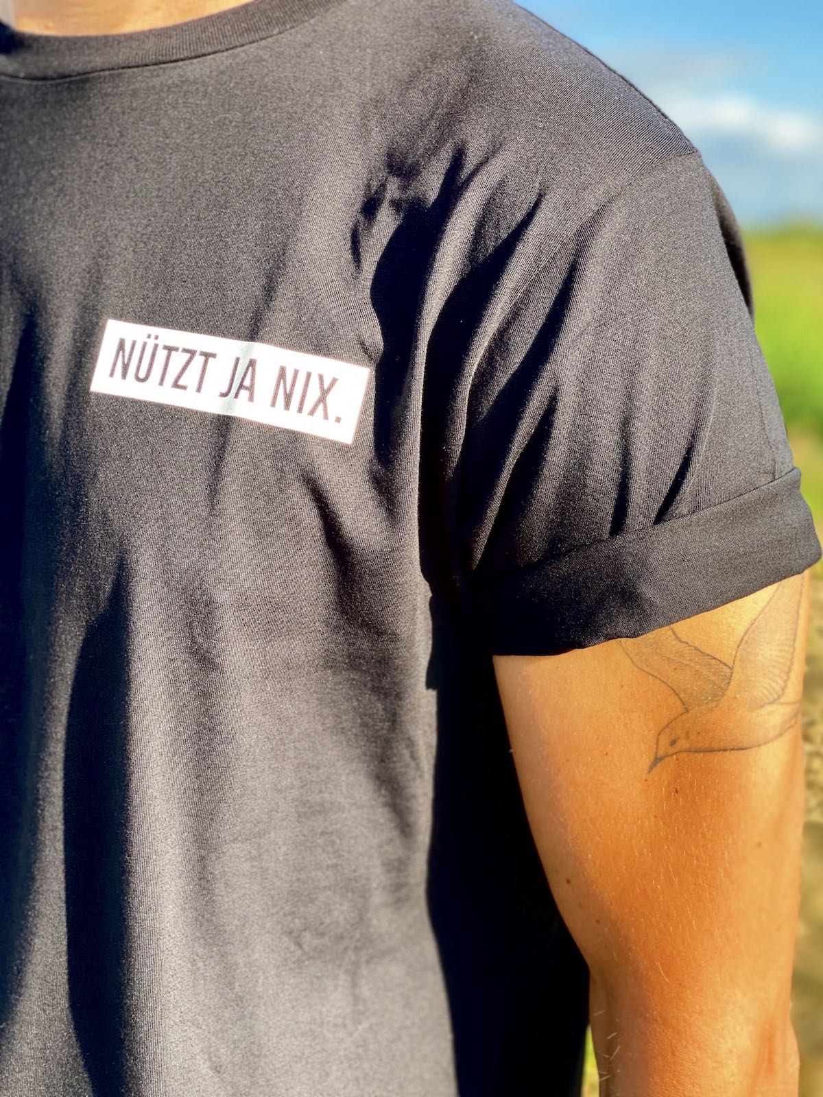 Schwarzes Herren T-Shirt mit "Nützt ja nix" Logo